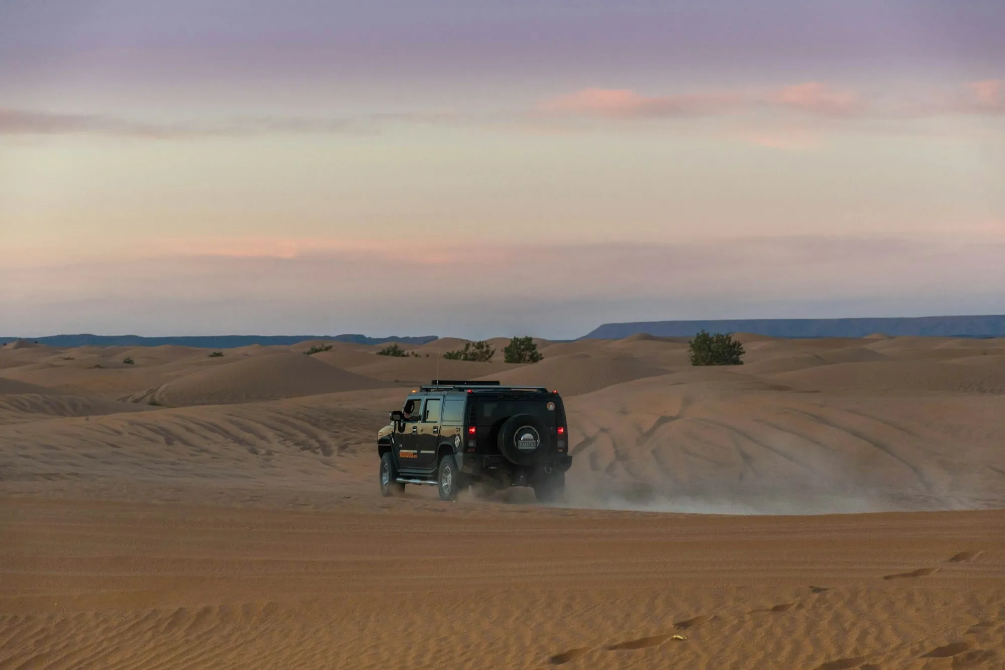 Todoterreno cruzando las dunas al atardecer
