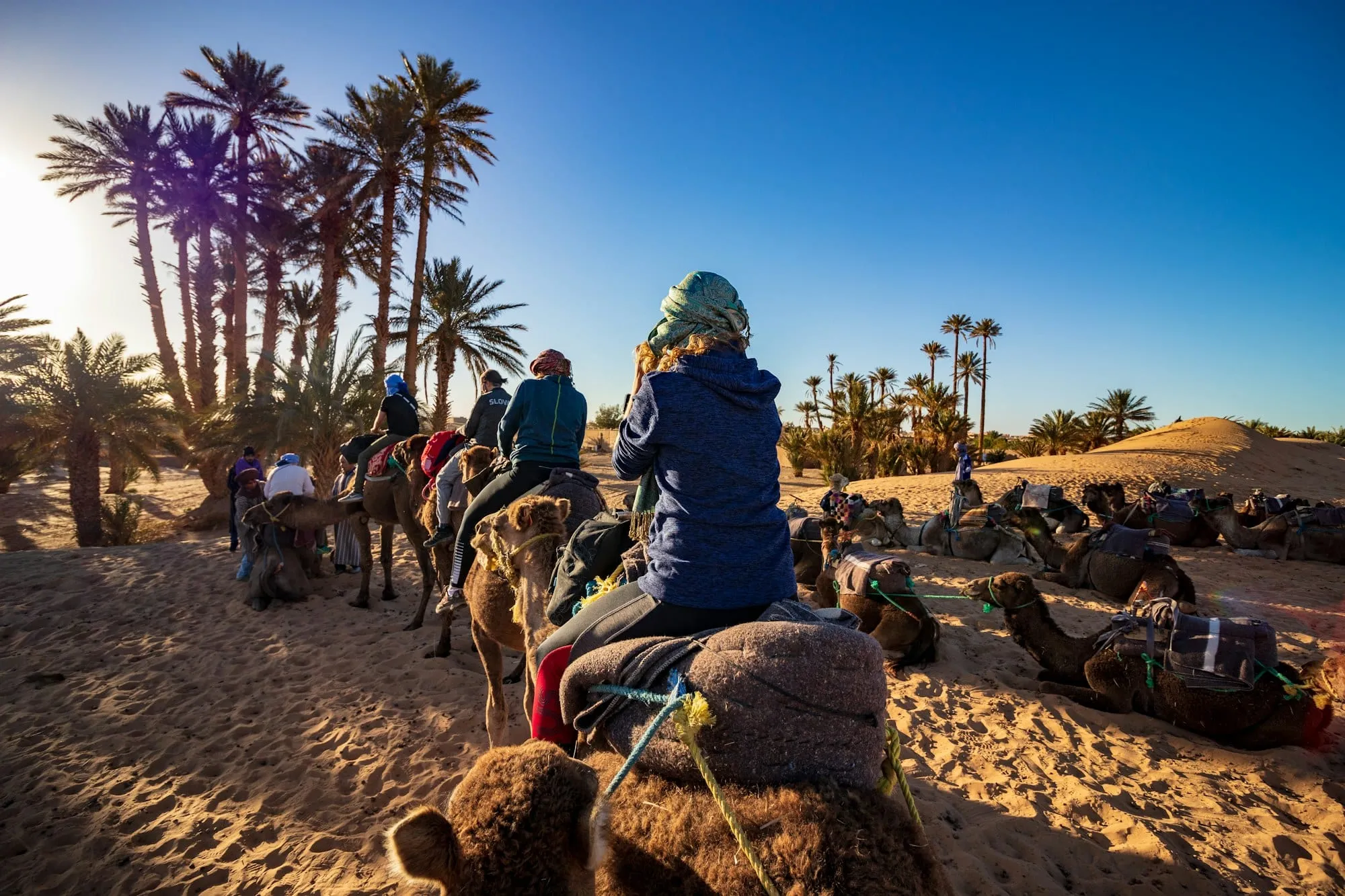 Familia paseando en dromedario por las dunas