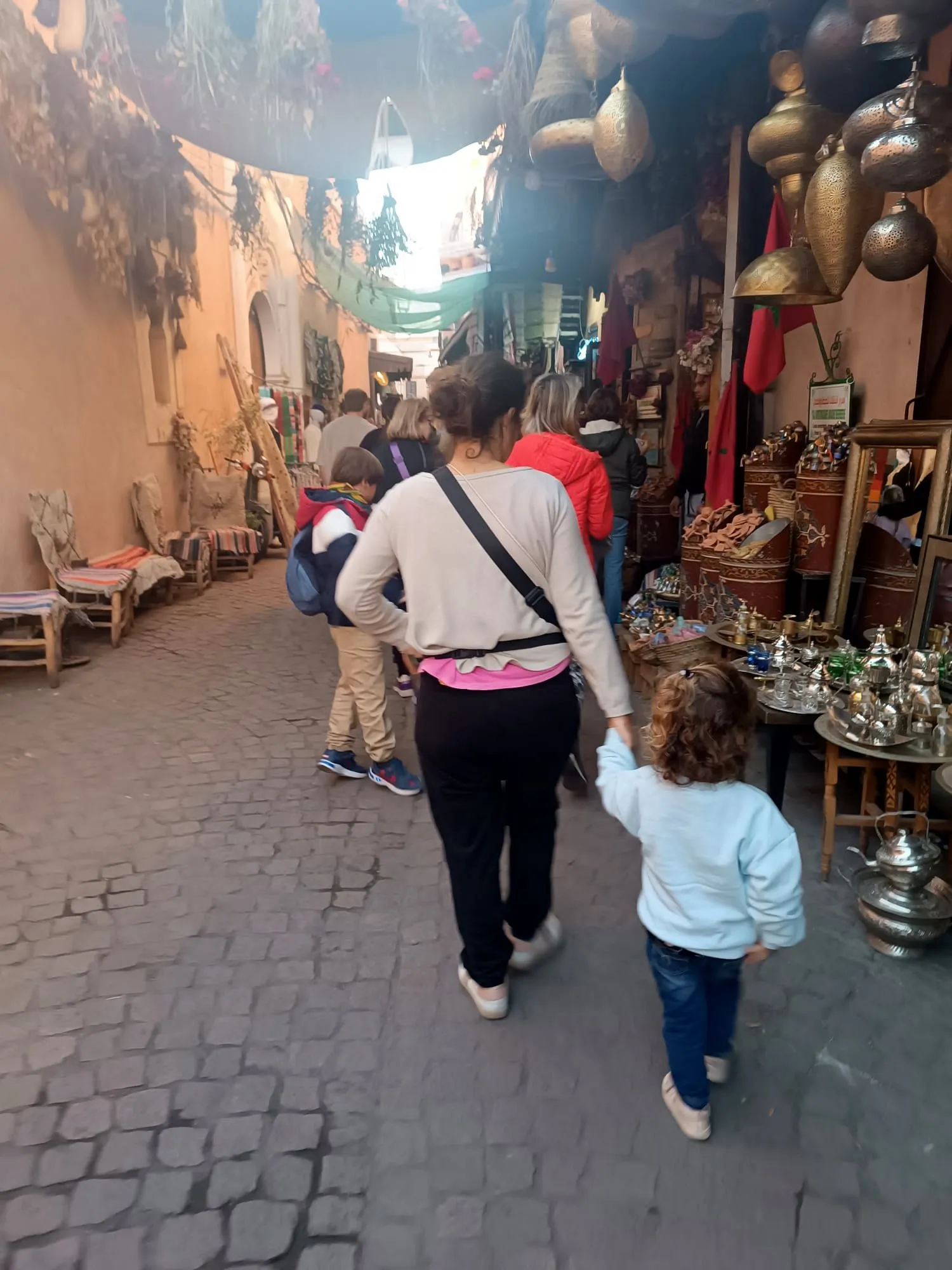 Una madre y su hijo paseando por un zoco, en el viaje de otro año