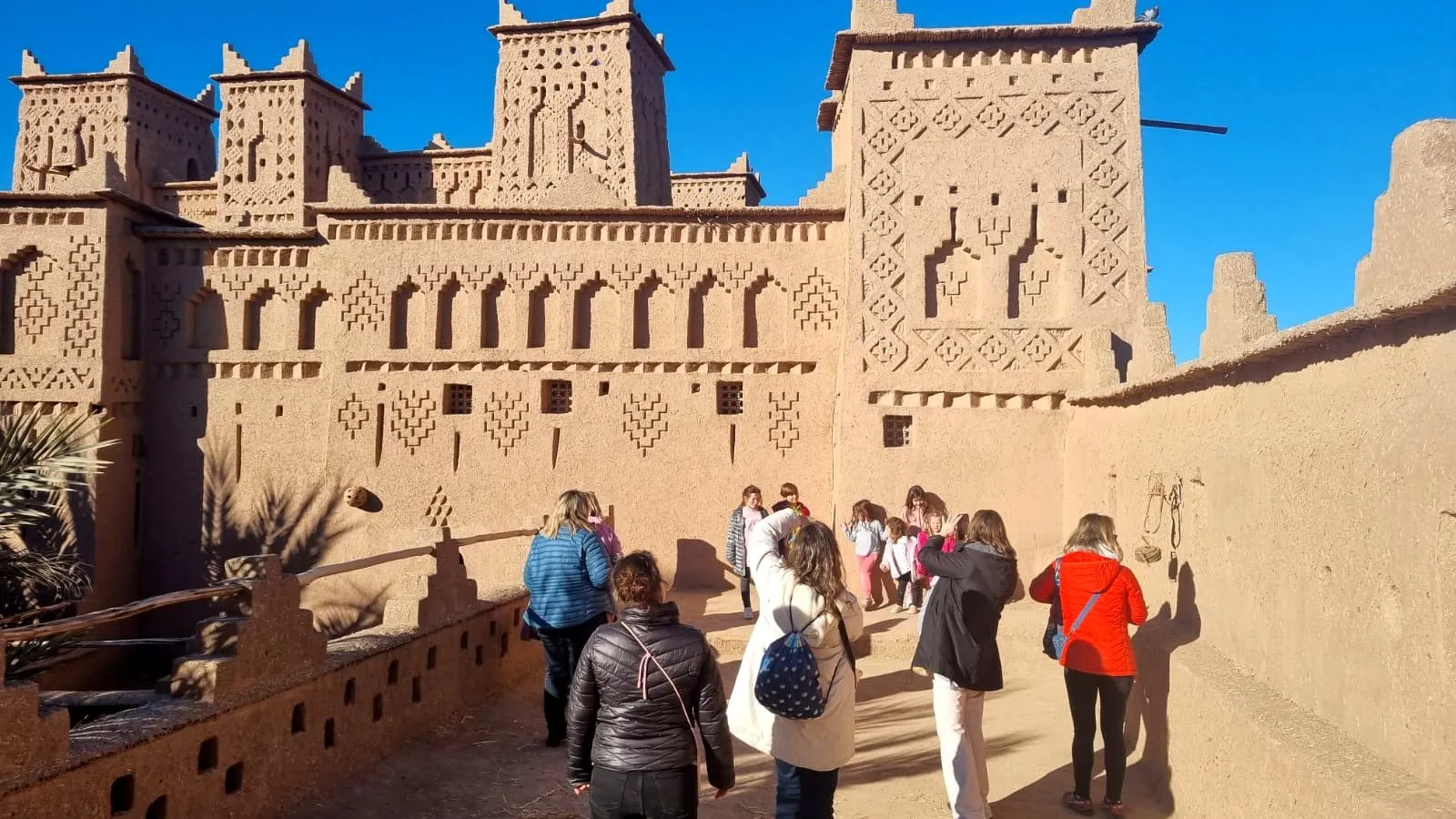 Un grupo de familias visitando una kasbah de adobe en el sur de Marruecos