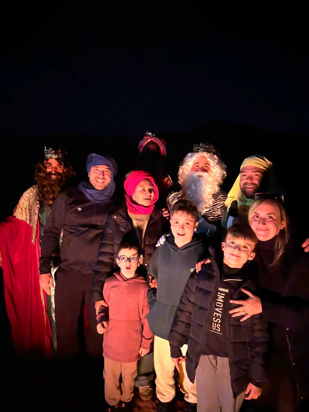 Los Reyes Magos con las familias en el campamento del desierto, de noche, en el viaje de otro año