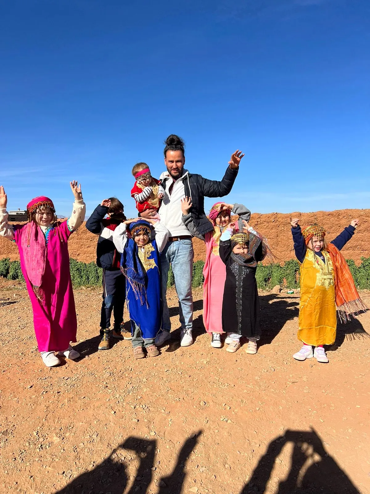 El grupo con ropa tradicional de colores en el desierto, en el viaje de otro año