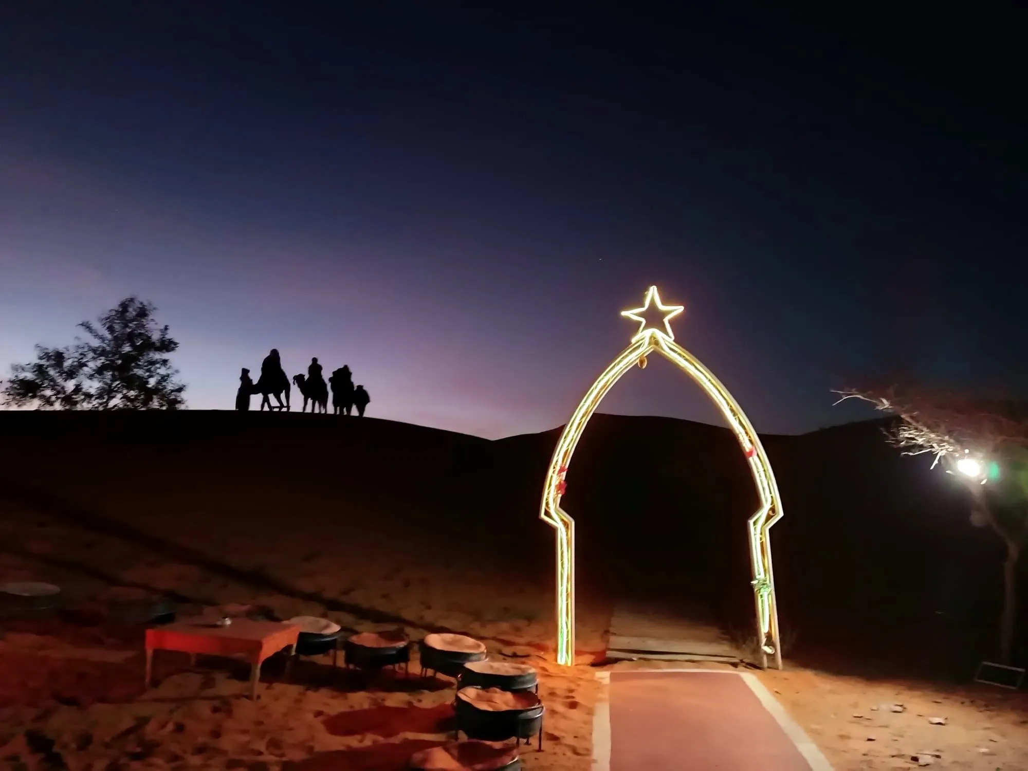 Arco con una estrella iluminada en el campamento de haimas, en el viaje de otro año